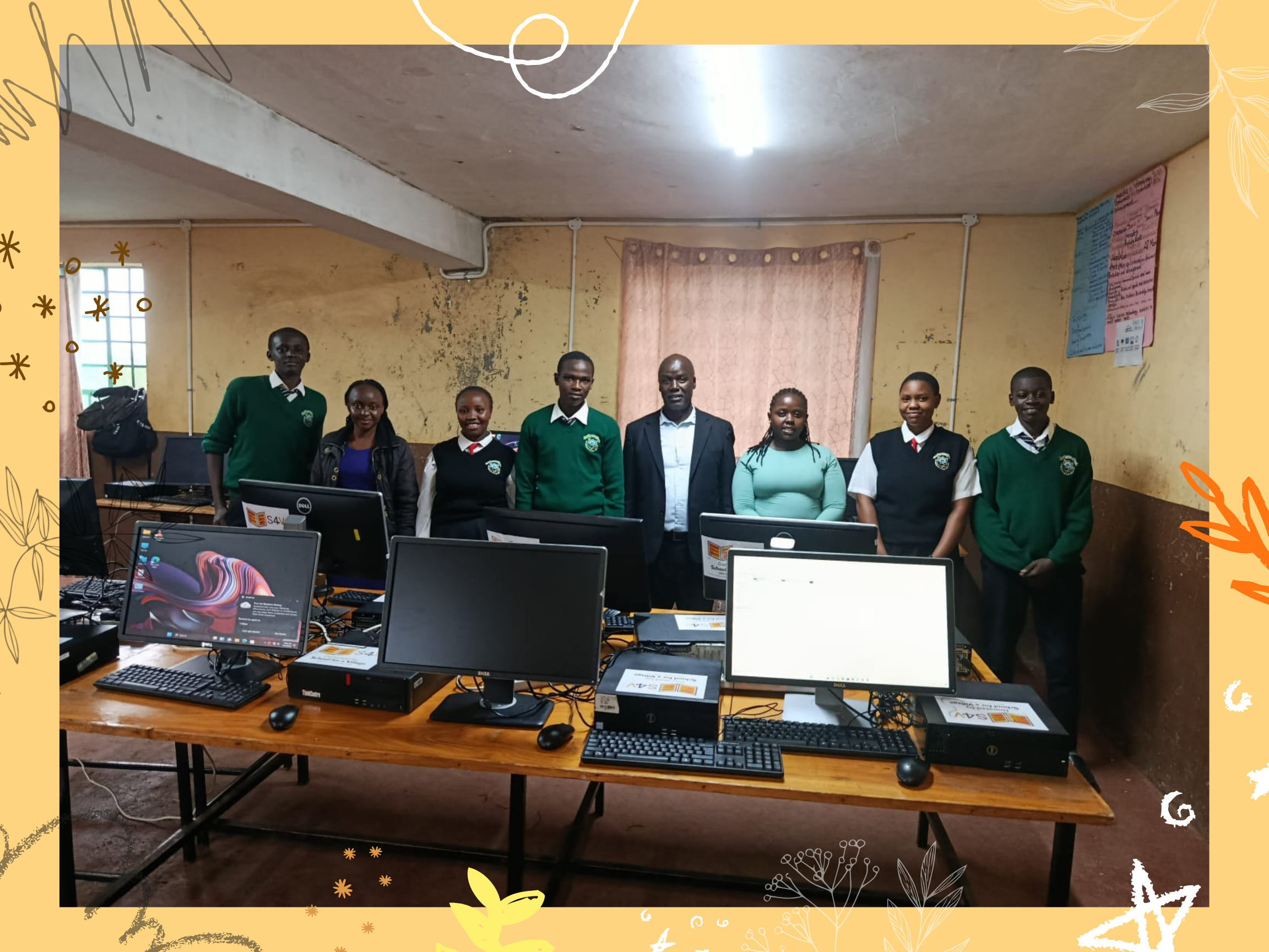 Students, admin, and Leah group photo in front of computers